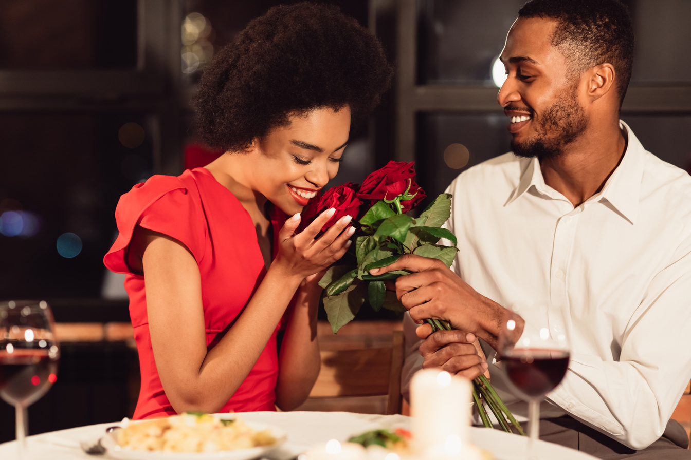 Loving Boyfriend Giving Girlfriend Bouquet Dating Having Dinner In Restaurant